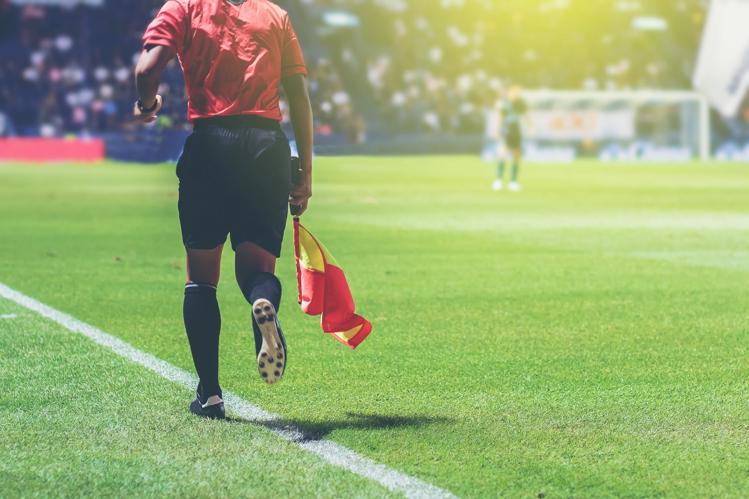 FC Friedrichstadt – Fußballverein – Lineman-Schiedsrichterassistent mit Fahne neben einem Fußballfeld.