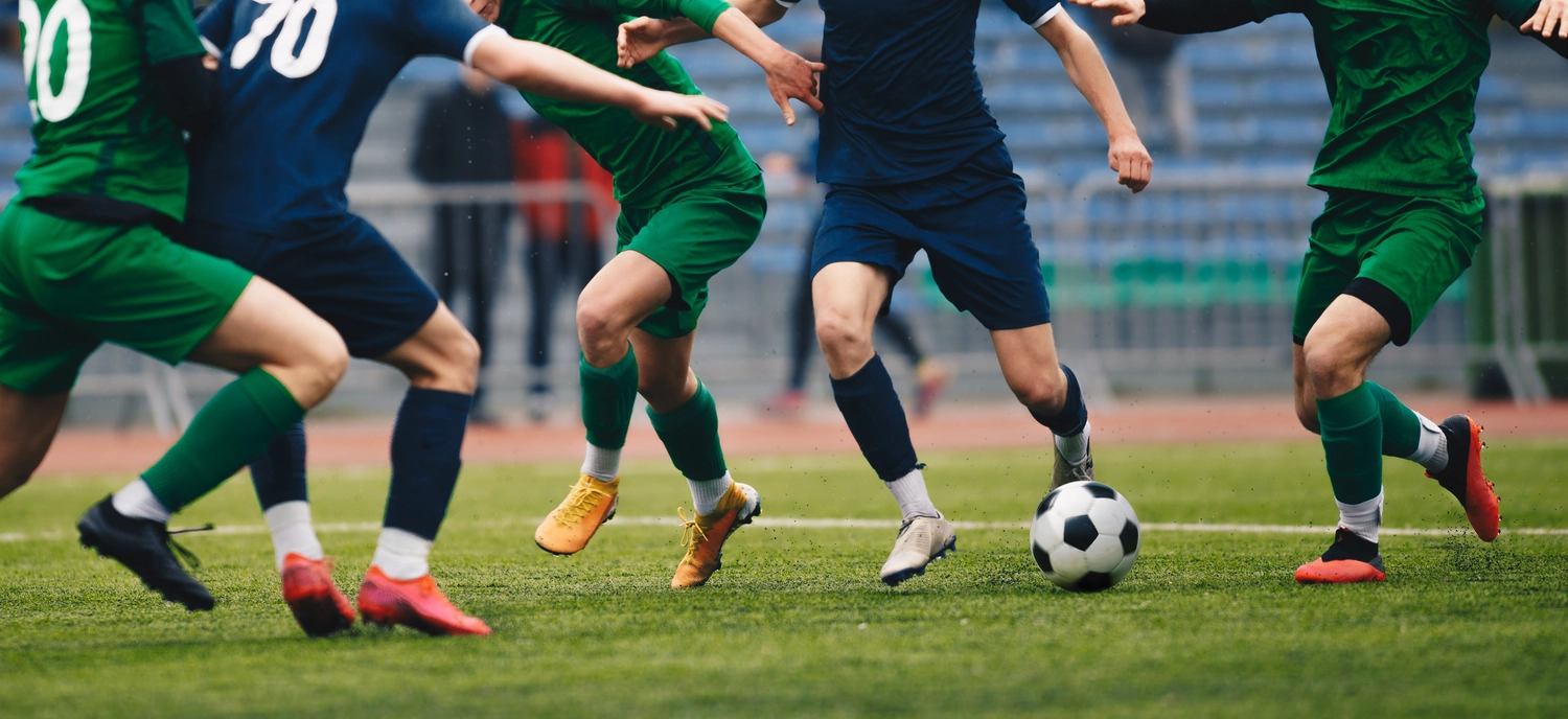 FC Friedrichstadt - Fußballverein - Fußballspieler dribbelt einen Ball und tritt während eines Spiels im Stadion einen Ball.
