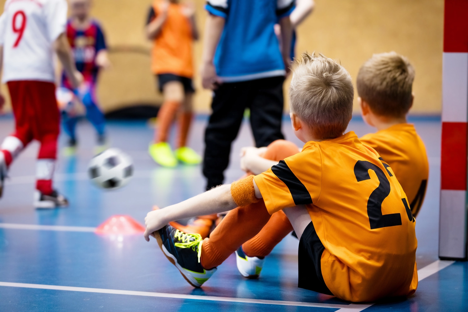 FC Friedrichstadt - Fußballverein - Kinder im Futsal-Training. Hallenfußballkurs für Kinder in der Schulsporthalle. Kinder kicken Fußbälle auf dem hölzernen Futsal-Boden